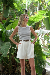 a lady in a striped crop top and a pair of white shorts